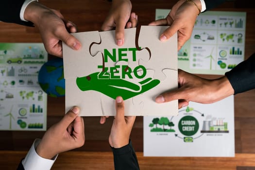 Top view cohesive group of business people forming jigsaw puzzle pieces in net zero icon symbol as eco corporate responsibility to reduce CO2 emission as sustainable solution for greener Earth. Quaint