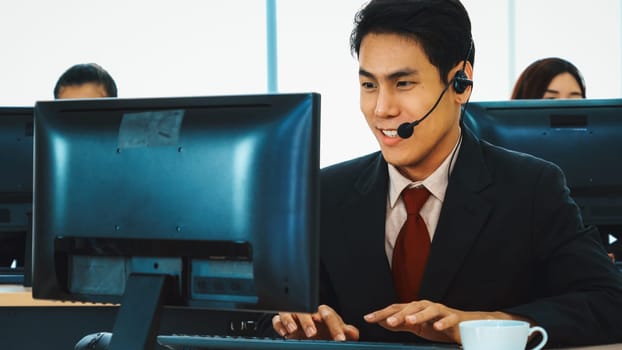 Business people wearing headset working in office to support remote customer or colleague. Call center, telemarketing, customer support agent provide service on telephone video conference call. Jivy