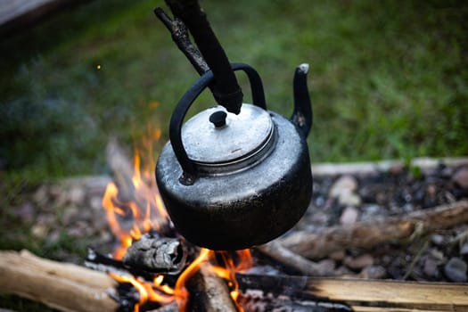 Vintage coffee pot on camping fire. The concept of adventure, travel, tourism and camping.