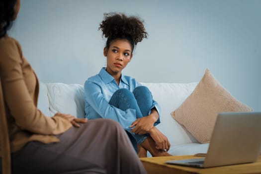 Sad PTSD woman patient in crucial therapy for mental health with psychologist, depression or grief after life failure. Frustrated trauma young woman talking to a psychologist about emotion in clinic