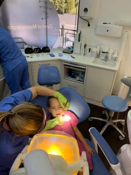 Little girl sitting in a dental chair at a doctor appointment. High quality photo