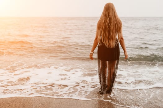 Woman travel sea. Young Happy woman in a long red dress posing on a beach near the sea on background of volcanic rocks, like in Iceland, sharing travel adventure journey