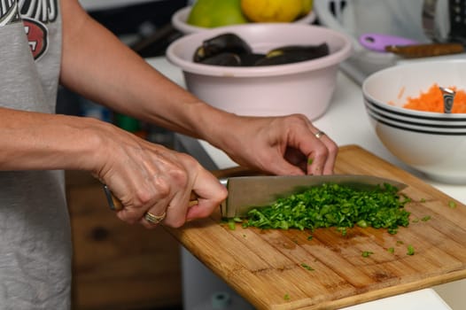 woman cutting parsley on a cutting board in the kitchen 4