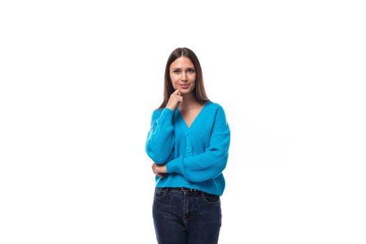young beautiful european brunette woman dressed in a blue cardigan with buttons and v-neck.