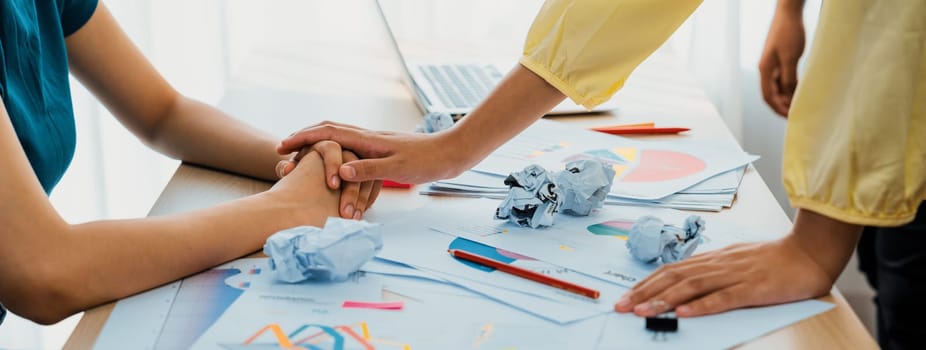 Panorama startup employee holding hand to stressed colleague due to failure, frustrated from no inspiration, lack of idea. Exhausted from overwhelm work and supportive coworker concept. Synergic