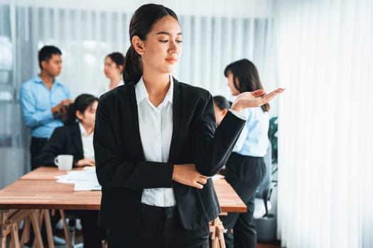 Portrait of happy young asian businesswoman looking at camera with motion blur background of business people movement in dynamic business meeting. Habiliment