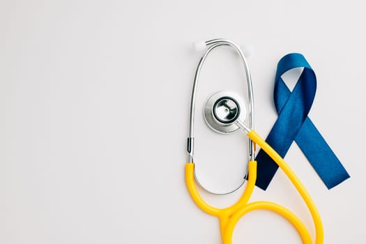 In support of men's health awareness campaigns in November and September, this image features a stethoscope and an awareness blue ribbon. Regular check-ups and care are fundamental.