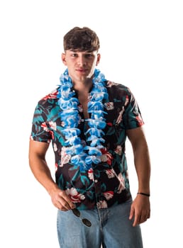 A man in a hawaiian shirt with a blue flower lei necklace around his neck. Handsome Young Man in a Hawaiian Shirt with a Blue Flower Lei