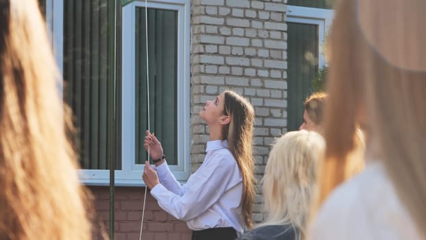 A student raises the flag of the country on the days of knowledge