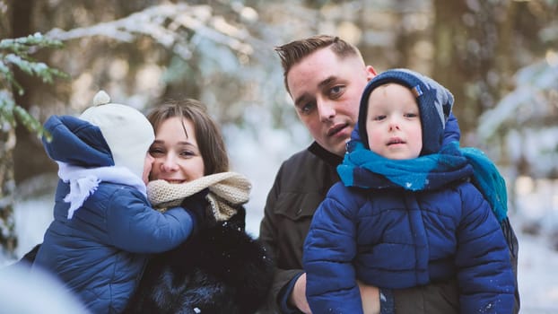 A happy family enjoying a winter sunny day in the woods