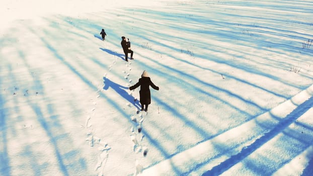 A family walks through a snow-covered field