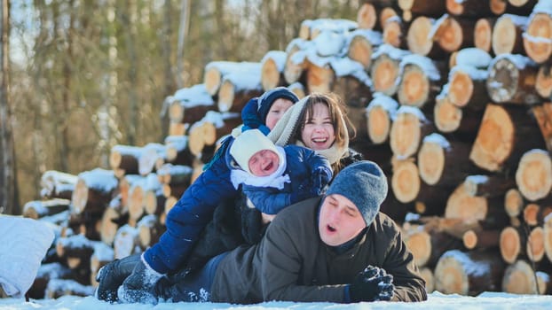 A happy family lying in the snow on a winter's day