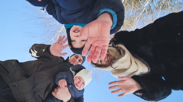 A young family throws snow at the lens on a winter day