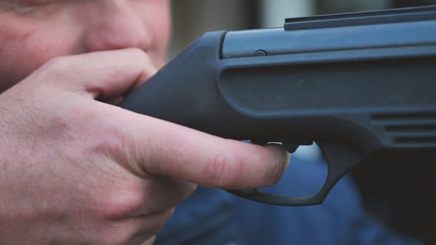 A man firing an air gun. Close-up of her hands