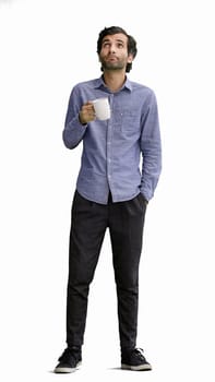 young man in full growth. isolated on white background. holding a mug of coffee.