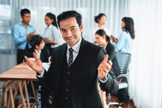 Portrait of happy businessman looking at camera with motion blur background of business people movement in dynamic business meeting. Habiliment