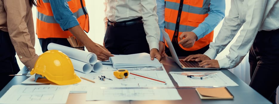 Engineer partner drawing and working on blueprint design together on office table for architectural building construction project. Architect drafting interior blueprint layout. Insight