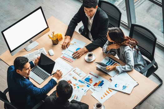 Business people group meeting shot from top view in office . Profession businesswomen, businessmen and office workers working in team conference with project planning document on meeting table . Jivy