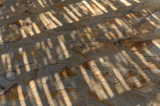 the sun shines through the thatched roof onto the stone floor, shadow and light