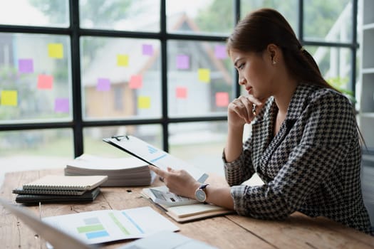 female employee holds a pen and checks investment financial documents