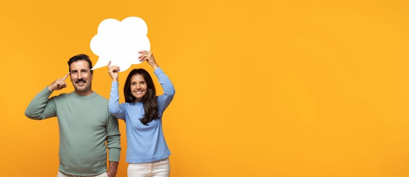Cheerful senior caucasian lady in casual hold abstract bubble for think, dream, words with free space at man, isolated on orange studio background, panorama. Relationships help, idea creation