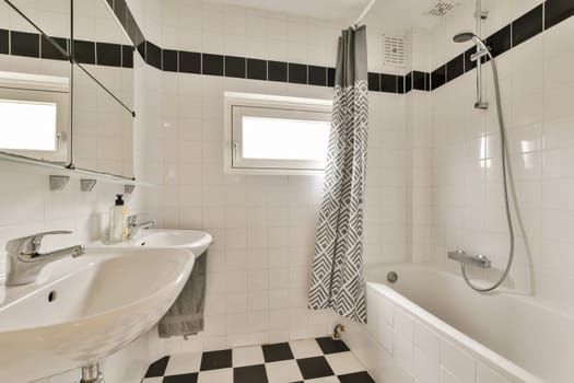 a white bathroom with black and white tiles on the floor, tub, sink, and shower stall in it