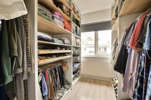a walk - in closet with lots of clothes hanging on the wall and shelves holding various men's shirts