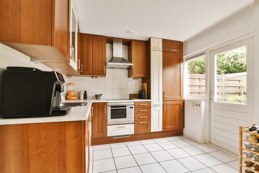 a kitchen with wood cabinets and white tile flooring in the middle of the room, there is a microwave on the counter
