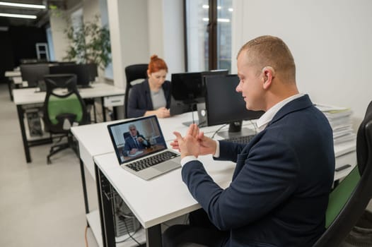 Business partners are talking in sign language to a video call. Two men at a remote business meeting