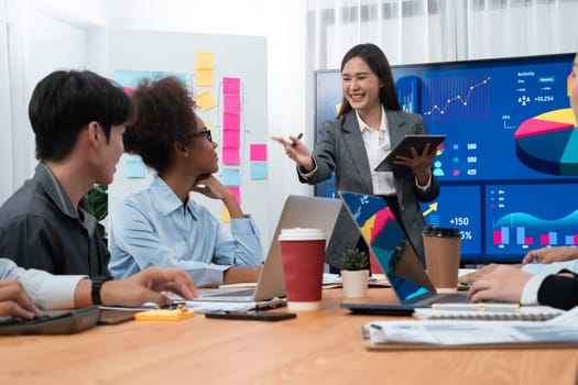 Young asian businesswoman presenting data analysis dashboard on TV screen in modern meeting. Business presentation with group of business people in conference room. Concord