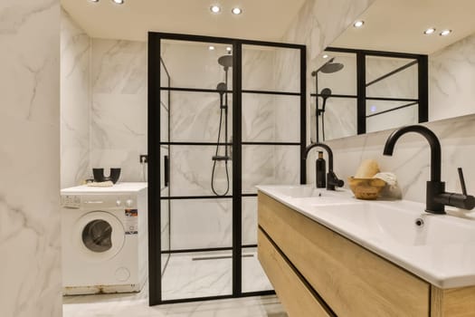 a modern bathroom with white marble walls and black framed mirrors on the wall, there is a washer in the corner