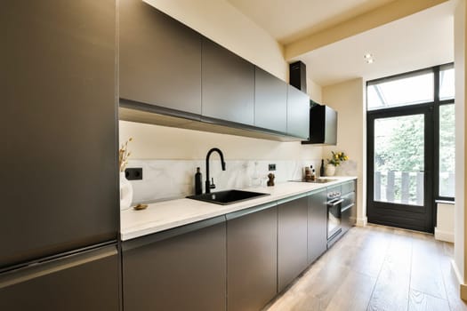 a modern kitchen with black cabinets and white counter tops on the island in this small space is ideal for entertaining