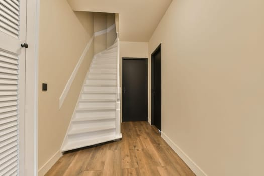 an empty room with wooden floors and white shutters on the walls, there is a staircase leading up to the second floor
