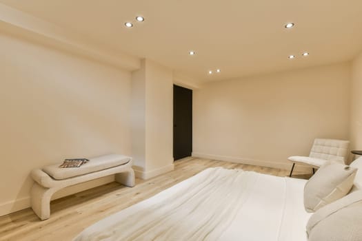 a bedroom with white walls and wood flooring in the middle, there is a bed on the right side