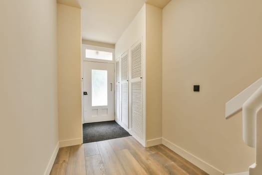 an empty room with wood flooring and white shutters on the wall behind it is a door that leads to another room