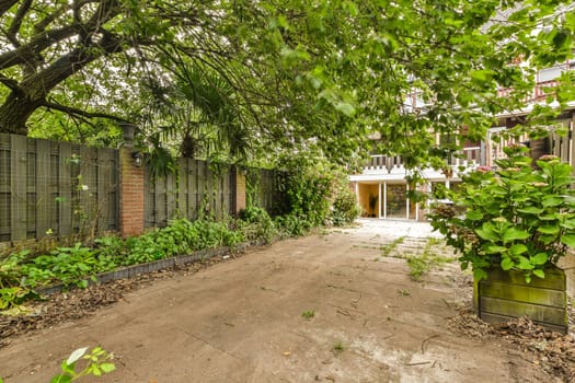 an abandoned house with trees and plants growing on the ground in front of it, surrounded by green foliages