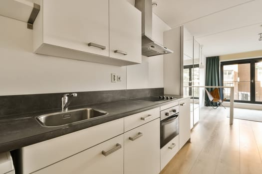 a kitchen with white cupboards and black counter tops on the counters in this apartment is very well equipped for entertaining