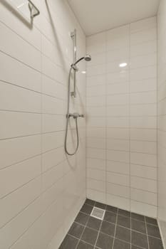 a walk in shower with tile flooring and white tiles on the wall behind it is an open shower stall