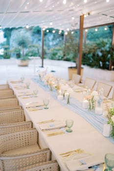 Festive long table with a strip of blue fabric in the middle. High quality photo