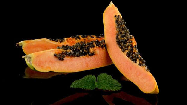 Slices of sweet papaya on black background.