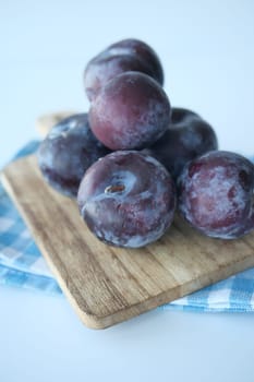 Fresh plums in a bowl on table ,