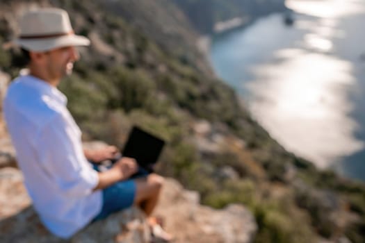 freelancer businessman working remotely on laptop at the beach near the sea