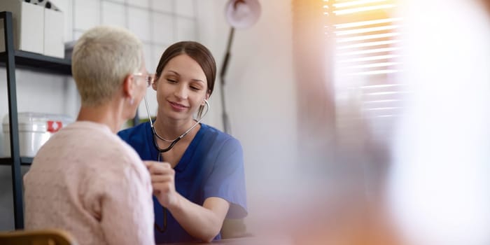 Physical therapist caregiver give advice about medicine to a senior women patient in rehabilitation. Physiotherapy healthcare, Medical caregiver consulting disabled elderly patient at home.