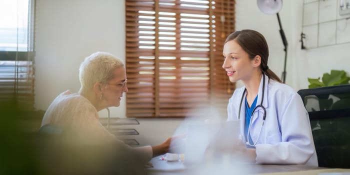 doctor discussion results or symptoms and gives Give advice about medicine to a senior women patient, giving consultation during medical examination in clinic.