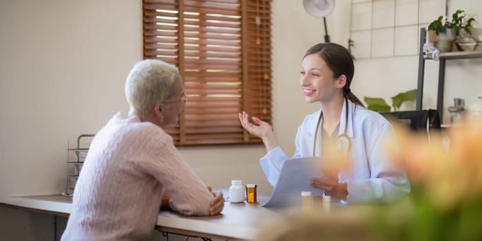 doctor discussion results or symptoms and gives Give advice about medicine to a senior women patient, giving consultation during medical examination in clinic.