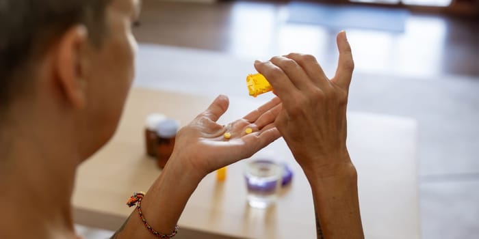 Medicine and healthcare of senior woman taking daily pill for ill, medication and sick elderly with medical drugs, vitamin or supplement in his hand.