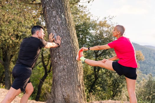 couple of man and woman stretching and warming up for training in the countryside, concept of sport in nature and active lifestyle