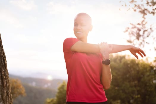 sportswoman stretching and warming up for training in the countryside, concept of sport in nature and active lifestyle