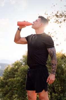 man drinking water during her training, concept of sport in nature and healthy lifestyle