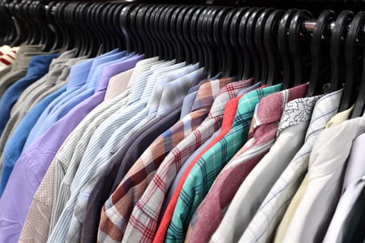 Cotton shirts hanging in a row in a store